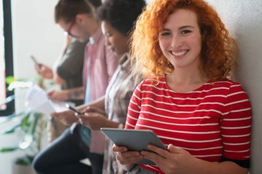 Modern başlangıç ofisinde takım olarak çalışan çok ırklı iş adamları ve yazılım geliştiricileri grubu