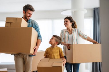 Yeni ev, kutu ve çocuklu aileler, yeni ev kredisi ve gayrimenkul yatırımları. Ev sahibi, taşınma günü için heyecanlı aile, taşınma ve kiralama konsepti