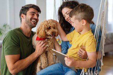 Mutlu aile, çocuklu ebeveynler başvuru ile eğleniyor, video karikatür izliyor ya da evde birlikte oyun oynuyorlar..