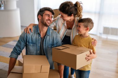 Yeni bir apartmanda kutularla taşınan çocuklu mutlu bir aile. Ev sahibi, taşınma günü için heyecanlı aile, taşınma ve kiralama konsepti