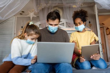 Farklı bir baba dizüstü bilgisayarda çalışırken kızı ona evde online toplantısı olduğunu hatırlatıyor. Hastalık, virüs, hastalık yüzünden koruyucu maskeler takıyorlar.