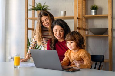 Aynı anda birden fazla iş yapan anne. Kadın çocuklarıyla dijital cihazların keyfini çıkarıyor ve evde eğlenceli anlar yaşıyor. İnsanlar, teknoloji kavramı