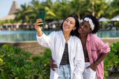 Moda dijital yaratıcısı çift sahilde şık bir selfie çekiyor, sosyal medya için seyahat içeriğini paylaşıyor, cennetteki etkili yaşam tarzını yaşıyorlar.