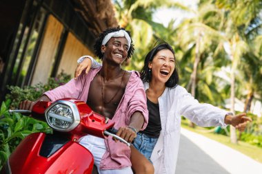 Mutlu çift kumsalda eğleniyor, romantik bir ortamda birlikte gülüyor, aşklarını güçlendiriyor ve güneşin tadını çıkarıyor.