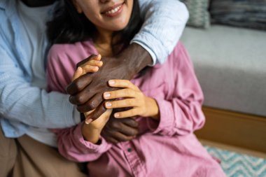 Farklı etnik kökenlere sahip insanlar arasında bir tokalaşma, güveni, uyumu, ait olmayı ve birliği sembolize eder. Mutlu ve dengeli bir çift el ele tutuşuyor..