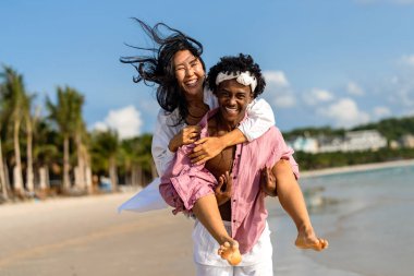 Romantik bir plaj kaçamağının keyfini çıkaran ırklar arası bir çift tropik bir cennette sevgi, kahkaha ve birlikteliği kucaklıyor.
