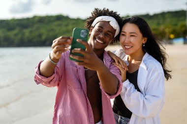 Çeşitli çiftler, arkadaşlar her zaman bağlanır, teknolojiyi ve sosyal medyayı kucaklarlar, dijital çağda çevrimiçi kalarak sahilde kaygısız anların tadını çıkarırlar.