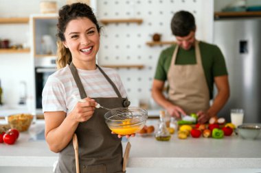 Genç mutlu çift evlerinde, mutfakta birlikte sağlıklı bir yemek hazırlıyorlar. Sağlıklı yaşam tarzı, kaliteli zaman, mutluluk, insan kavramı