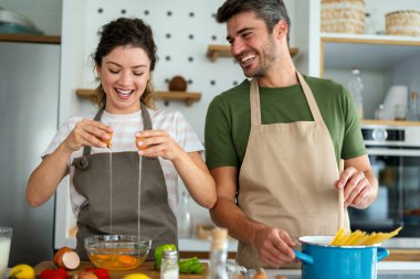 Gizli bileşen aşktır. Güzel genç çift evde boş vakit geçirirken birlikte sağlıklı bir yemek hazırlıyor.