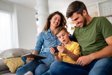 Mutlu teknoloji bağımlısı aile babası ve çocuk evde dizüstü bilgisayar dijital tableti kullanıyor, sosyal medyayı aşırı kullanan cihazlara takıntılı çocuk, internet bağımlılığı kavramı