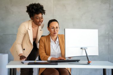 Modern ofisteki bilgisayarlarına bakan yaratıcı bir ekip. Tasarımcı, banka müdürü ve avukatlık bürosunda birlikte çalışan başarılı kadınlar..