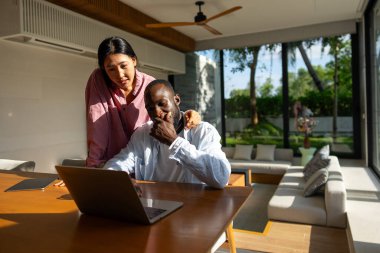 Mutlu, genç, etnik çeşitliliğe sahip çift planlama bütçesi, e-postada iyi haberler okumak, geri ödeme veya ipotek onayı, dizüstü bilgisayar ekranına bakan kadın ve erkek, mali durumları kontrol etmek.