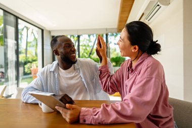 İş ekibi, iki mutlu çeşitlilik, çok ırklı yönetici ofiste dizüstü bilgisayar kullanarak birlikte çalışıyorlar. Genç iş kadını yöneticisi iş toplantısında sunum yapıyor, danışmanlık yapıyor.