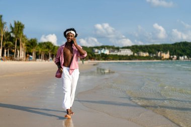 Moda dijital yaratıcısı sahilde şık bir selfie çekiyor, sosyal medya için seyahat içeriğini paylaşıyor, cennetteki etkili yaşam tarzını yaşıyor.