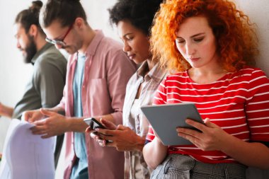 Mutlu iş arkadaşları, modern ofisteki iş arkadaşlarıyla iş başında ve toplantıdalar. Proje fikirlerini tartışmak veya strateji geliştirmek.