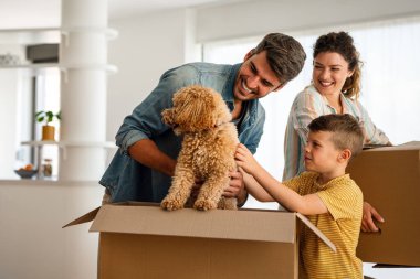 Yeni ev, kutu ve çocuklu aileler, yeni ev kredisi ve gayrimenkul yatırımları. Ev sahibi, taşınma günü için heyecanlı aile, taşınma ve kiralama konsepti