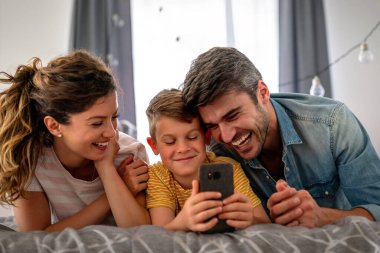 Üç kişilik bir aile evde neşeyle vakit geçirir. Çocukların iyi ruh hali ailelere zevk verir..