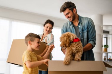 Yeni ev, kutu ve çocuklu aileler, yeni ev kredisi ve gayrimenkul yatırımları. Ev sahibi, taşınma günü için heyecanlı aile, taşınma ve kiralama konsepti