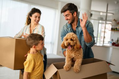 Yeni ev, kutu ve çocuklu aileler, yeni ev kredisi ve gayrimenkul yatırımları. Ev sahibi, taşınma günü için heyecanlı aile, taşınma ve kiralama konsepti