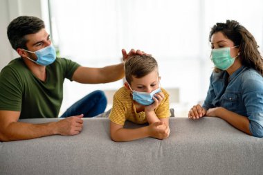 Virüsü, gribi ve kirliliği önlemek için koruyucu maske takan üzgün bir aile. Kirlenmiş hava konseptinden aile koruması
