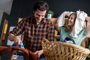 Mutlu bir baba ve kızı evde ev işleri yapıyor ve birlikte ütü yapıyor. İnsanların mutluluk kavramı.