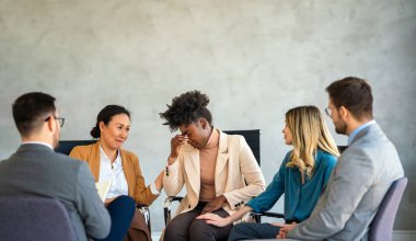 Grup terapisindeki insanlar ilginç bir konuşma yapıyorlar. Mutlu erkek ve kadın hastalar toplantı sırasında çember şeklinde konuşuyorlar. Tecrübeli bir koçun tavsiyelerini dinleyen iş arkadaşları.