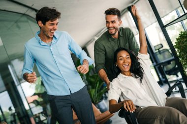 Bin yıllık çok ırklı takım insanlar eğlenmek oda ofis, heyecanlı farklı çalışanlar iş kopma komik faaliyet zevk gülüyor koltuklarda sürme yaratıcı samimi işçiler birlikte oyun oynamak