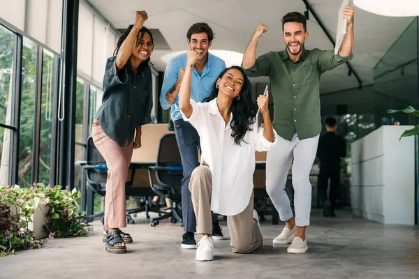 Coşkulu, çeşitli, etnik çeşitlilikte genç meslektaşlar ortak kurumsal başarıyı ya da hedef başarısını kutluyor, modern ofiste kaygısız parti zamanlarının tadını çıkarıyor.
