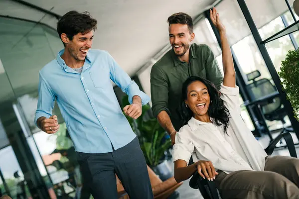 Bin yıllık çok ırklı takım insanlar eğlenmek oda ofis, heyecanlı farklı çalışanlar iş kopma komik faaliyet zevk gülüyor koltuklarda sürme yaratıcı samimi işçiler birlikte oyun oynamak