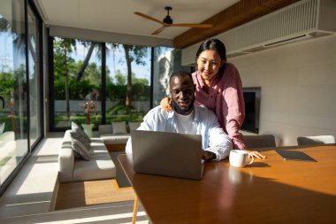 Uzaktan çalışan çok kültürlü bir çift, çevrimiçi finans ve yatırım planlıyorlar. Dijital göçebe yaşam tarzı, takım çalışması ve her yerden gelen akıllı finansal kararlar.