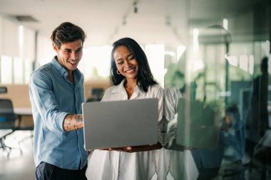 Ofisteki dijital cihazları kullanarak gülümseyen bir yönetici ekibi. Çeşitli profesyonel liderler yöneticiler ve çalışanlar takım çalışmasında çalışan dijital finans projesini tartışıyor.