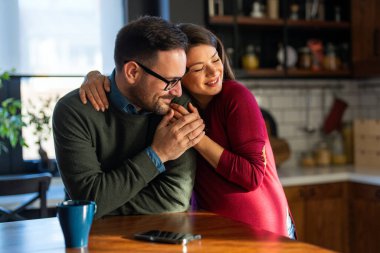 Aşk, şefkat, ilişki ve yeni aile kavramı. Aşık bir adam hamile karısına sarılır, birlikte bebeklerin gelmesini beklerler.