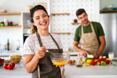 Gizli bileşen aşktır. Güzel genç çift evde boş vakit geçirirken birlikte sağlıklı bir yemek hazırlıyor.