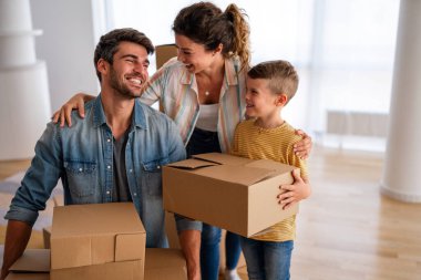 Taşınmak, ebeveynler ve çocuklar yeni evde aile zamanı için bir araya geliyorlar. Mutlu aile, ipotek ve ev için karton kutular açmak.