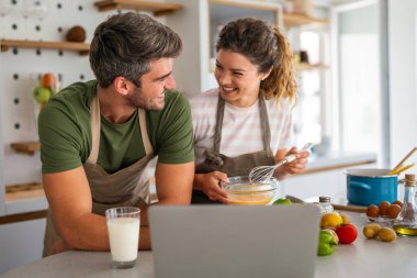 Gizli bileşen aşktır. Güzel genç çift evde boş vakit geçirirken birlikte sağlıklı bir yemek hazırlıyor.