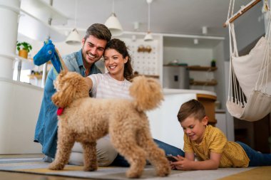 Mutlu bir aile oyunu, evde köpekle eğlenmek. Portre anne, baba ve çocuk oturma odasında kaliteli zaman, sevgi ve bakım için birlikte hafta sonu
