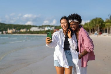 Çeşitli çiftler, arkadaşlar her zaman bağlanır, teknolojiyi ve sosyal medyayı kucaklarlar, dijital çağda çevrimiçi kalarak sahilde kaygısız anların tadını çıkarırlar.