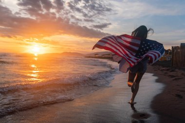 Mutlu kadın gülümseyip plajda koşarken bağımsızlık gününü kutluyor ve Amerika 'da özgürlüğün tadını çıkarıyor.