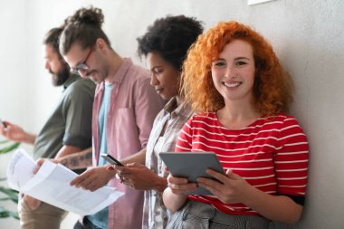 Modern bir iş yerinde çalışan mutlu genç bir kadının portresi, yeni bir iş arkadaşının mutluluk konsepti..