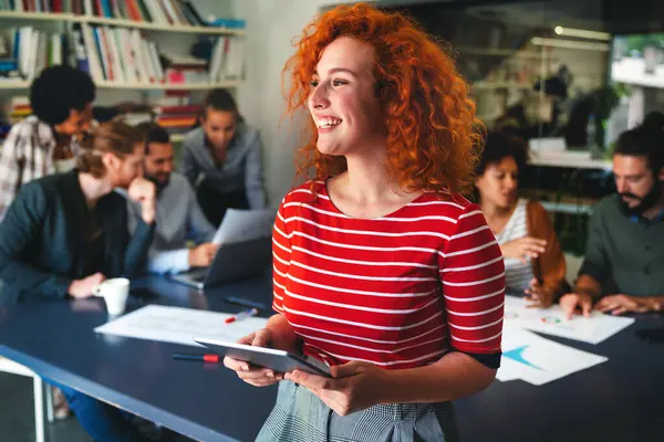 Modern bir iş yerinde çalışan mutlu genç bir kadının portresi, yeni bir iş arkadaşının mutluluk konsepti..
