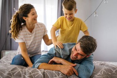 Üç kişilik bir aile evde neşeyle vakit geçirir. Çocukların iyi ruh hali ailelere zevk verir..