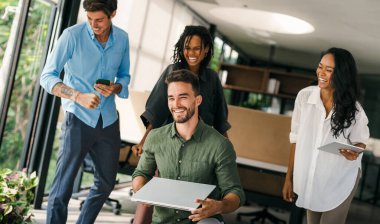 İş projesi ekibi şirket ofisindeki toplantı odasında birlikte çalışıyor.