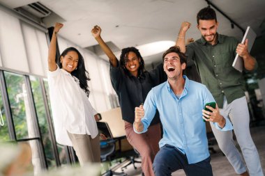 Ofisteki dijital cihazları kullanarak gülümseyen bir yönetici ekibi. Çeşitli profesyonel liderler yöneticiler ve çalışanlar takım çalışmasında çalışan dijital finans projesini tartışıyor.