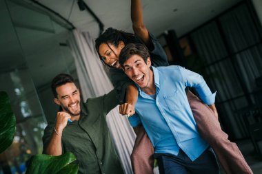 Mutlu iş arkadaşları ofiste birlikte eğleniyor. Erkek çalışanlar kadınları sırtında tutuyor. İş molalarında ya da partilerde tuhaf oyunlar oynuyorlar.