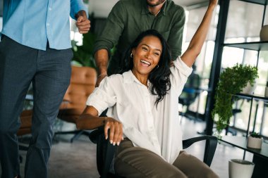 Bin yıllık çok ırklı takım insanlar eğlenmek oda ofis, heyecanlı farklı çalışanlar iş kopma komik faaliyet zevk gülüyor koltuklarda sürme yaratıcı samimi işçiler birlikte oyun oynamak