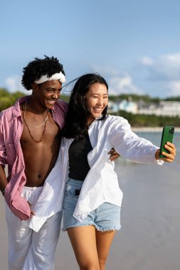 Çeşitli çiftler, arkadaşlar her zaman bağlanır, teknolojiyi ve sosyal medyayı kucaklarlar, dijital çağda çevrimiçi kalarak sahilde kaygısız anların tadını çıkarırlar.