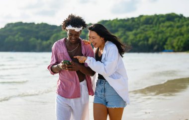 Çeşitli çiftler, arkadaşlar her zaman bağlanır, teknolojiyi ve sosyal medyayı kucaklarlar, dijital çağda çevrimiçi kalarak sahilde kaygısız anların tadını çıkarırlar.