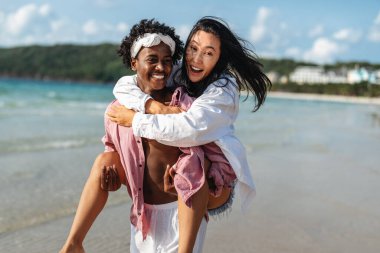 Saf mutluluk. Genç bir çift, tropikal kaçamaklarının her anından zevk alır. Oynar, güler ve cennette birlikte olmanın keyfini çıkarırlar.