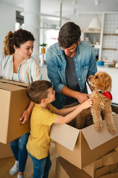 Taşınmak, ebeveynler ve çocuklar yeni evde aile zamanı için bir araya geliyorlar. Mutlu aile, ipotek ve ev için karton kutular açmak.