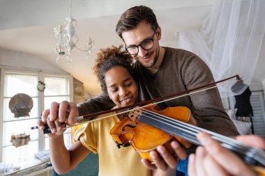 Özel müzik yakışıklı erkek öğretmen evde Afrikalı Amerikalı kıza keman dersleri veriyor.